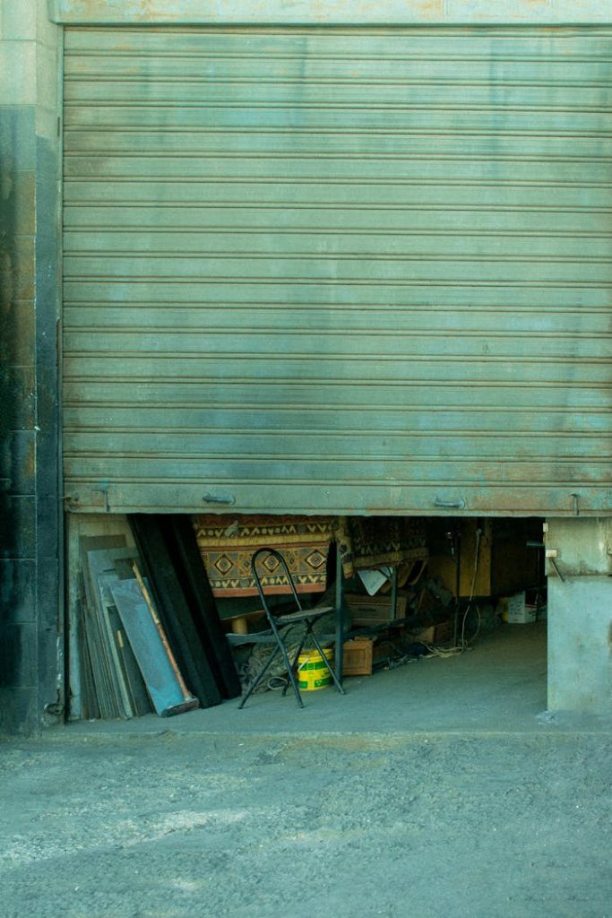 Partial view of a garage entrance with various items stored inside, exuding an urban industrial vibe.